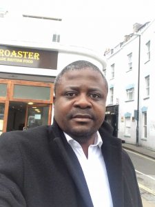 Man with black blazer and white shirt in street